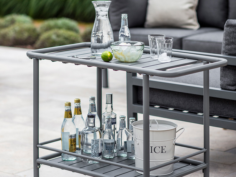 Drinks Trolley laid with glassware, drinks, bottles and lime on an outdoor patio