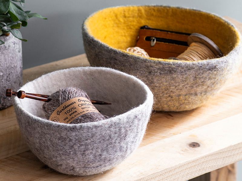 Faitrade Southwold Felt Bowls containing wooden knitting needles, wool and string